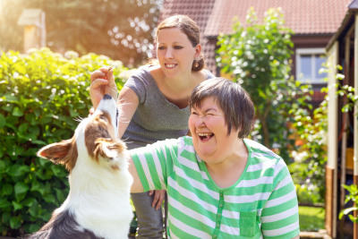 caregiver and her patient playing with dog